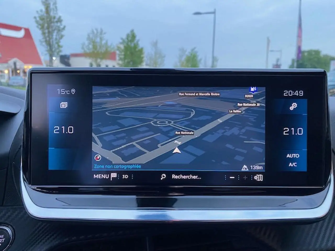 Écran tactile 7 pouces du système de navigation 3D du Peugeot 2008 blanc, affichant une carte de rue en soirée.