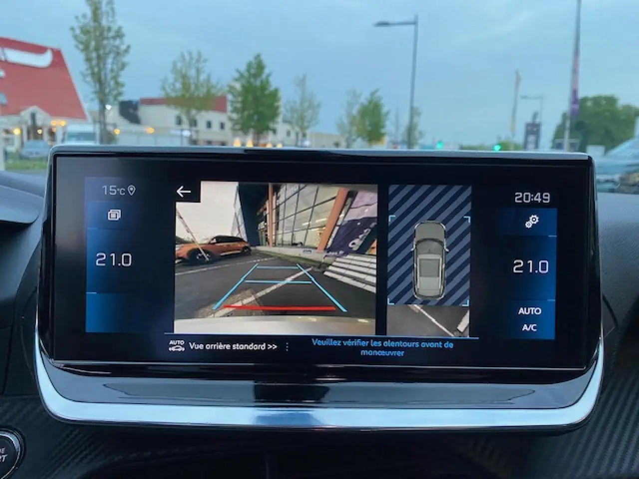 Écran tactile 7 pouces du Peugeot 2008 blanc montrant la caméra de recul et l'aide au stationnement.