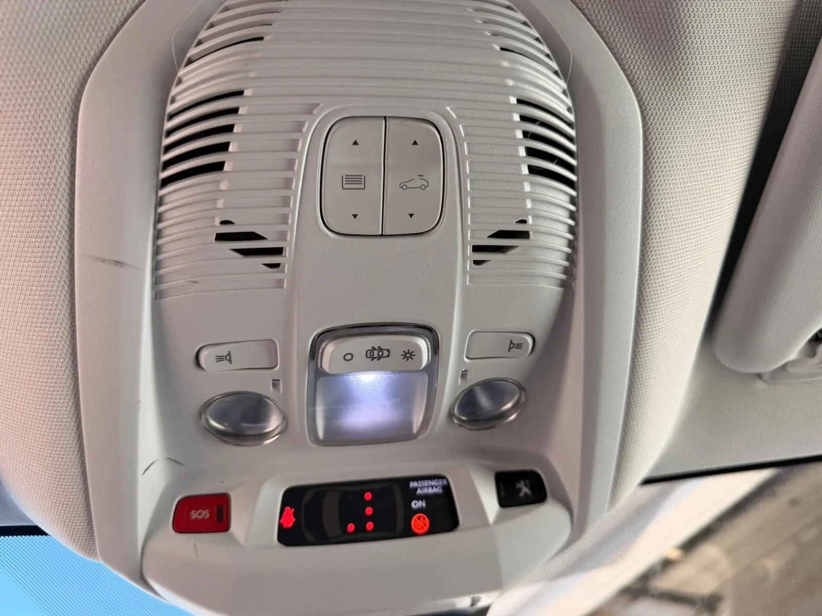 Vue en gros plan du plafonnier blanc nacré du Peugeot 3008 2019 avec boutons d'éclairage et alerte SOS.