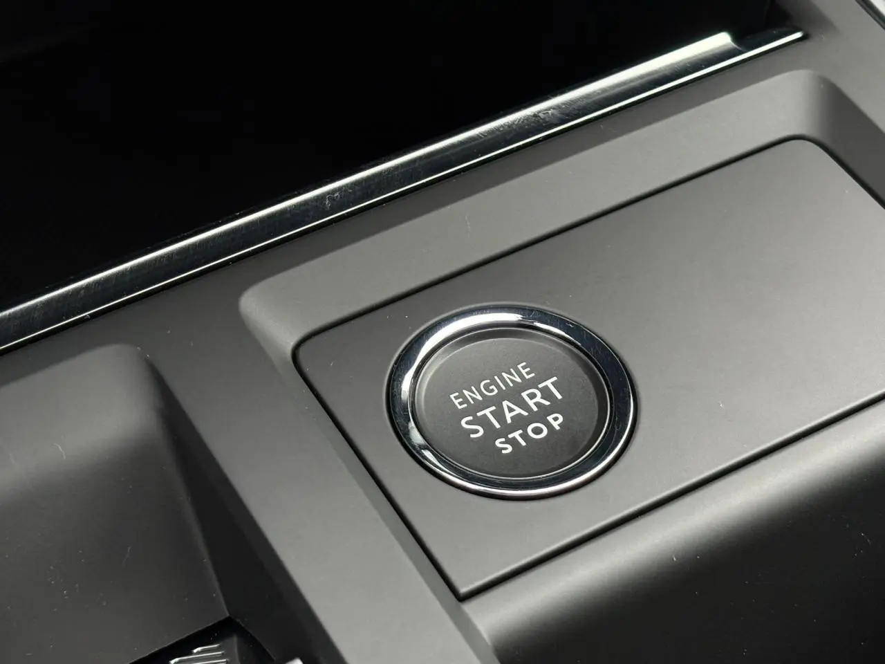 Gros plan sur le bouton moteur Start/Stop du Citroën C5 Aircross Hybrid 2025, entouré de plastique noir mat.