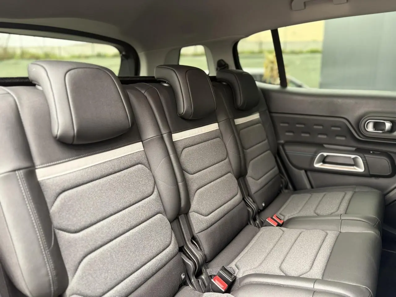 Vue latérale droite des trois sièges arrière indépendants en tissu et cuir noir du Citroën C5 Aircross Hybrid 2025.