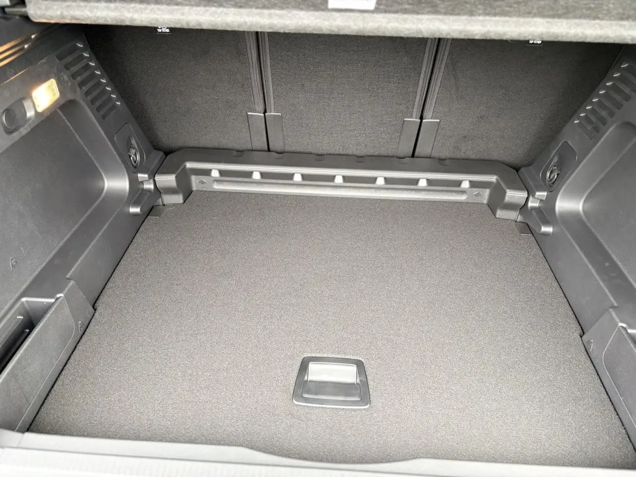 Coffre vu de face du Citroën C5 Aircross Hybrid noir, avec plancher plat et habillage intérieur gris foncé.