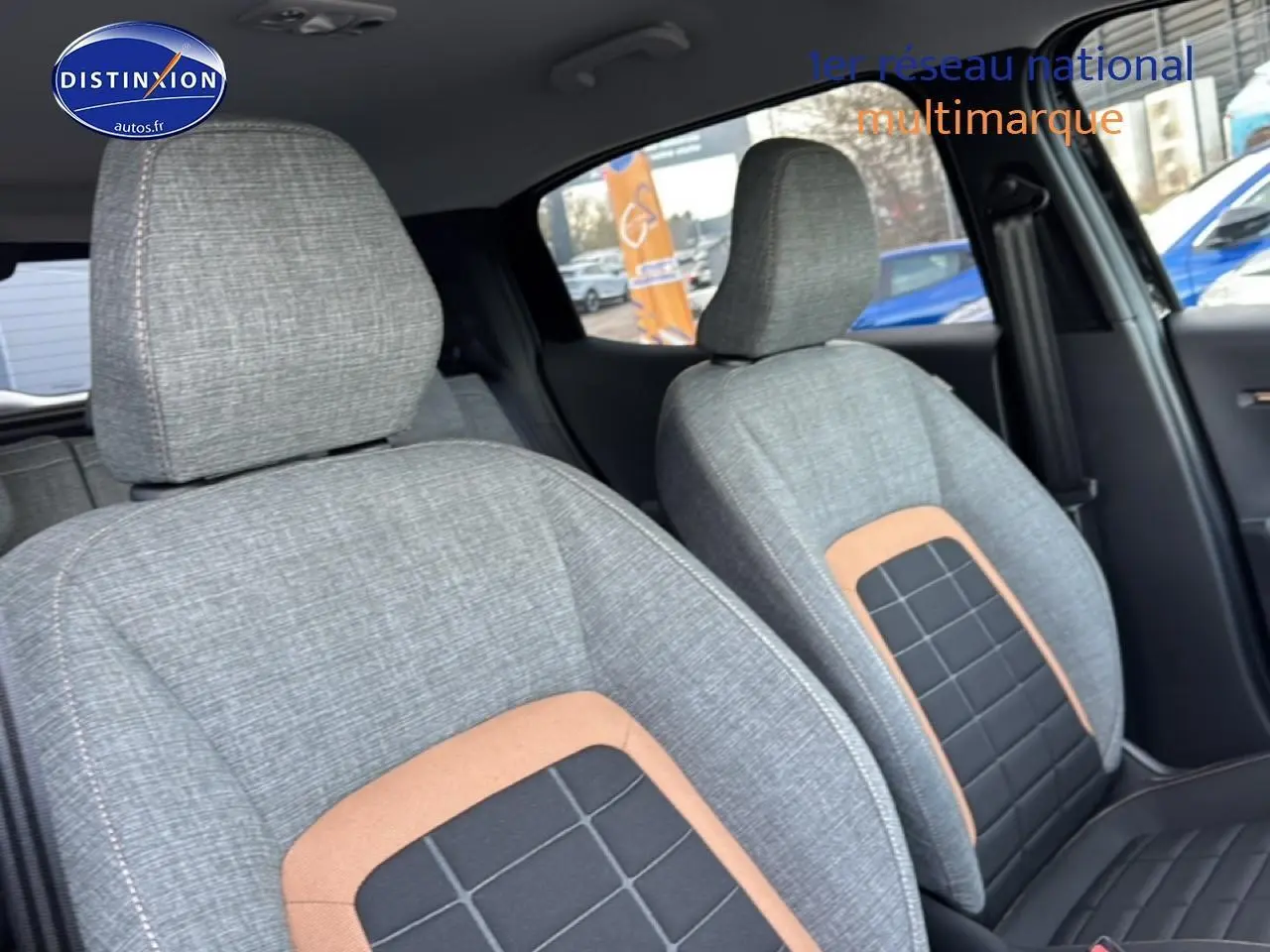 Vue intérieure rapprochée des sièges avant gris avec inserts noirs et marron dans une Citroën C3 Aircross 2025 noire.