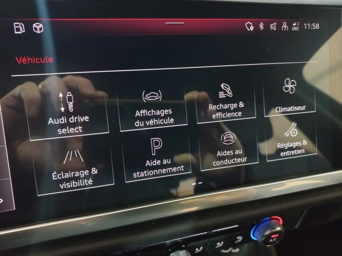 Écran tactile intérieur de l’Audi Q3 blanc 2021 affichant les options de conduite et d’aide au stationnement.