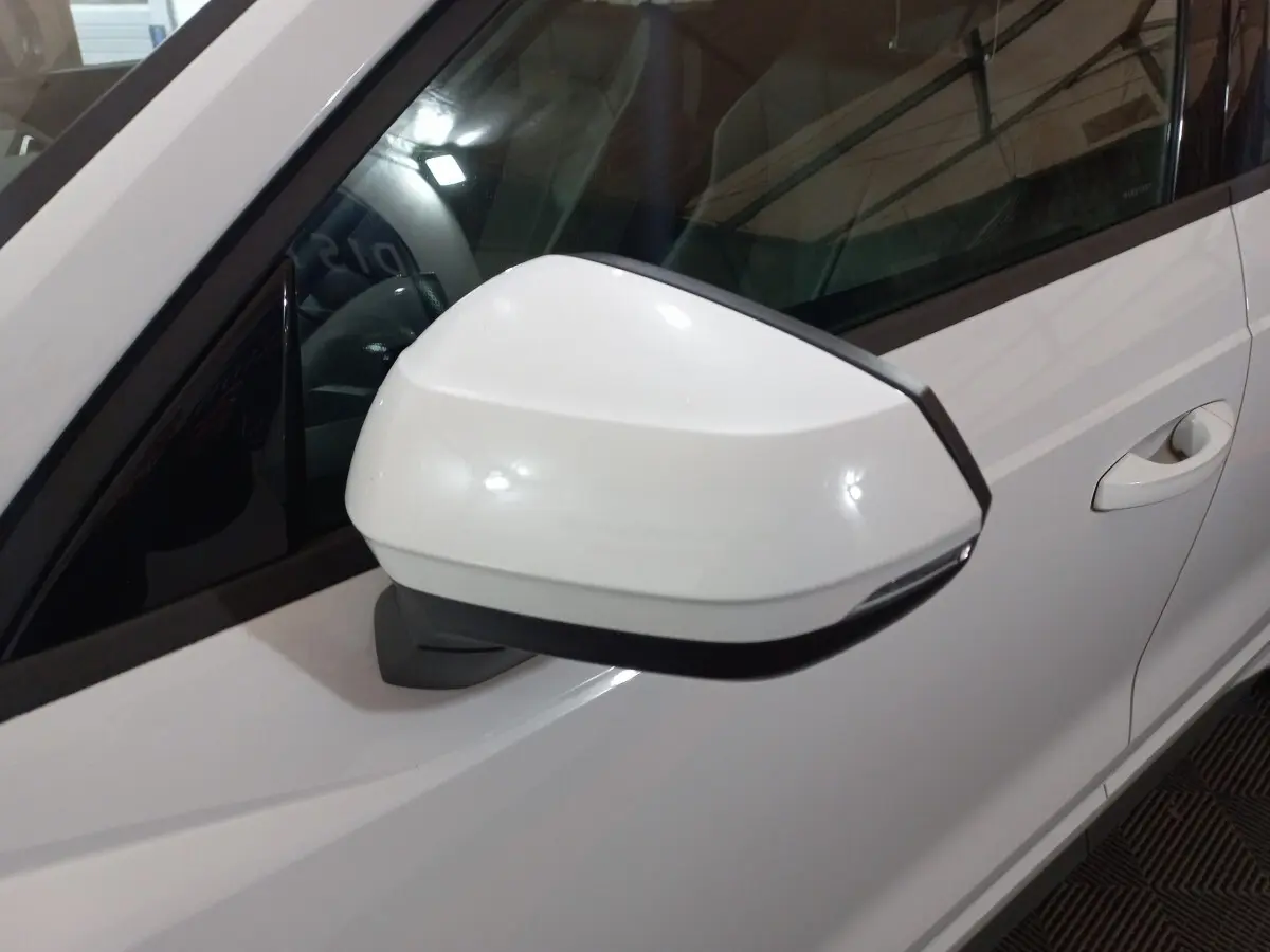 Rétroviseur droit blanc de l'Audi Q3 45 TFSI e S line 2021, avec porte et poignée visibles en arrière-plan.