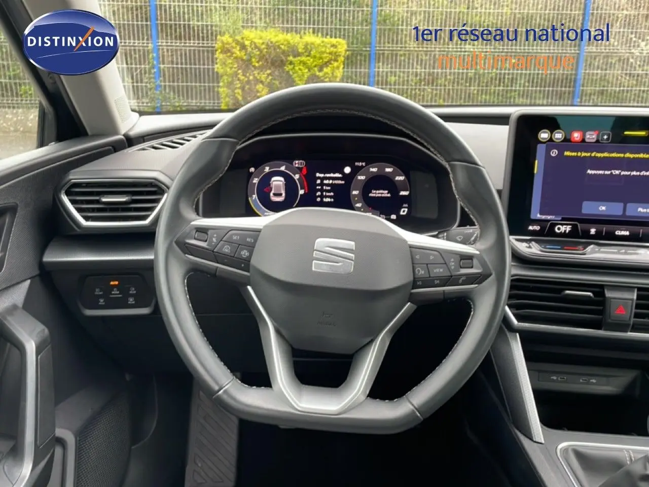 Vue centrée sur le volant cuir et le tableau de bord numérique de la SEAT LEON gris magnétique 2025.