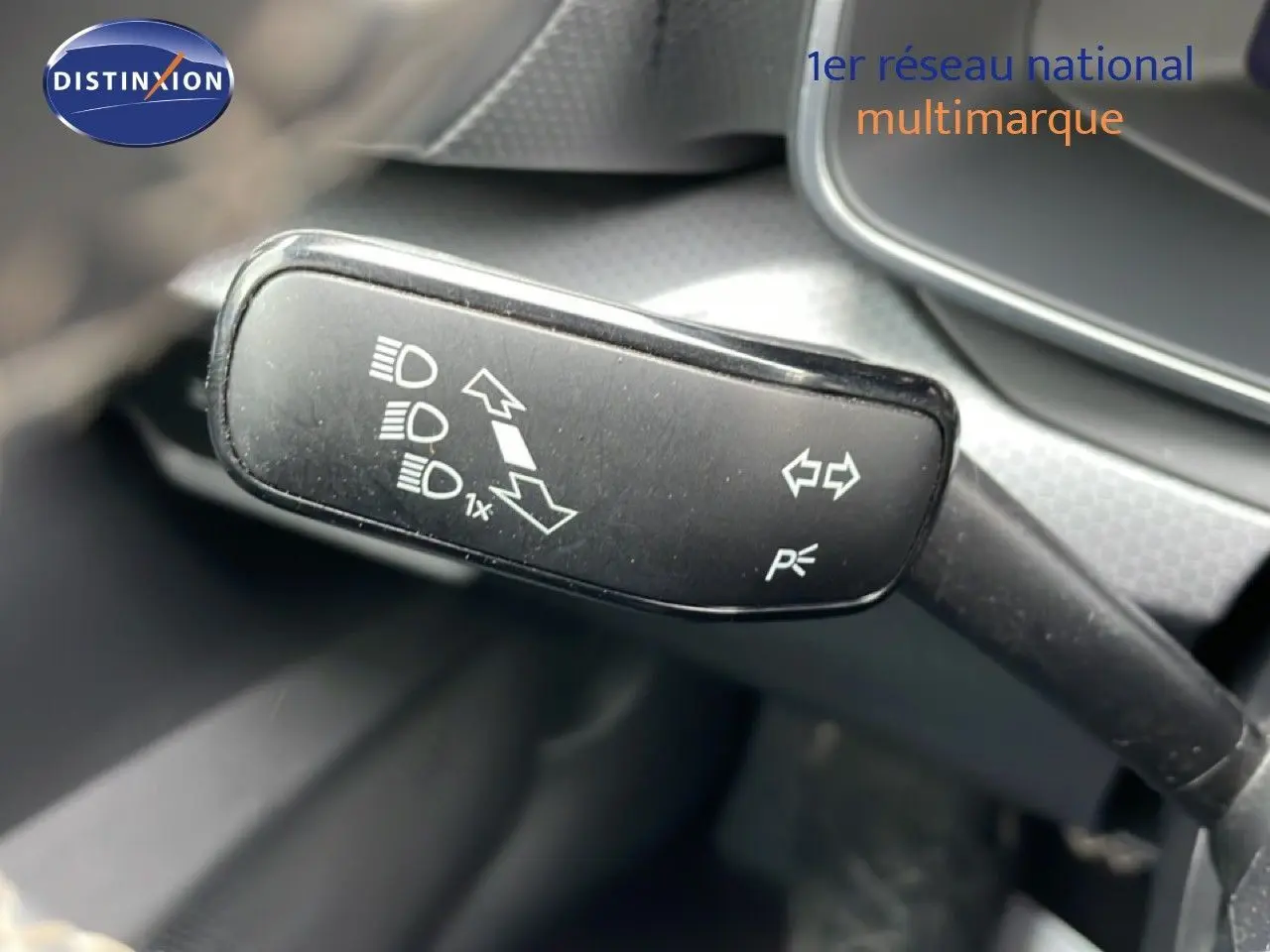 Gros plan sur la commande des feux et clignotants dans l’habitacle gris noir du SEAT Leon 2025.