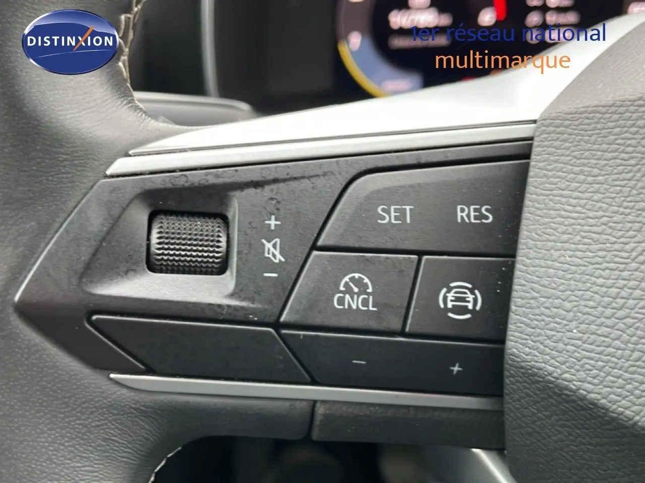 Détail du volant côté gauche d'une SEAT LEON 2.0 TDI 115CH STYLE XL 2025 gris magnétique, avec commandes de régulateur de vitesse.