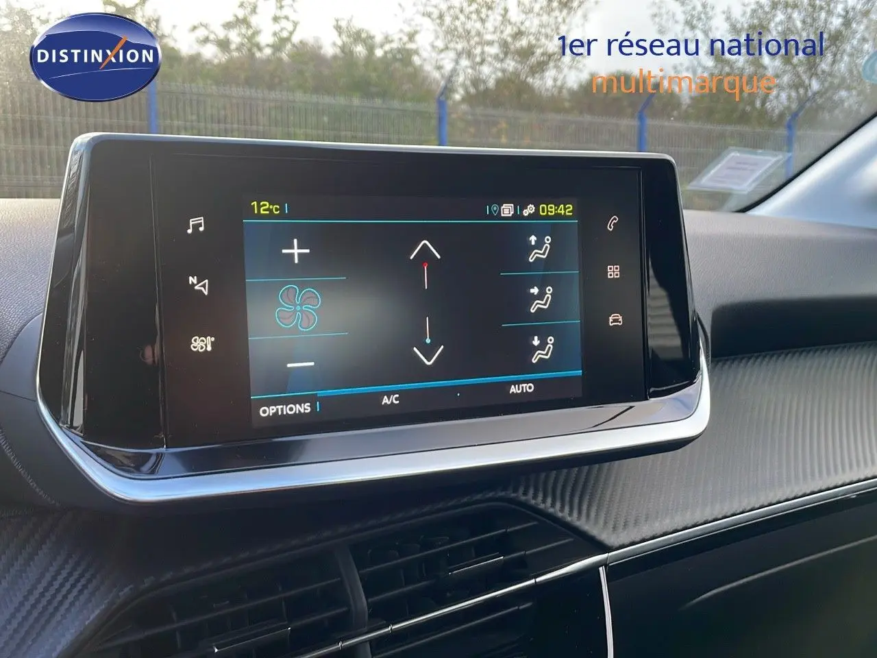 Écran tactile central affichant les commandes de climatisation dans l'habitacle d'une Peugeot 208 gris Artense.