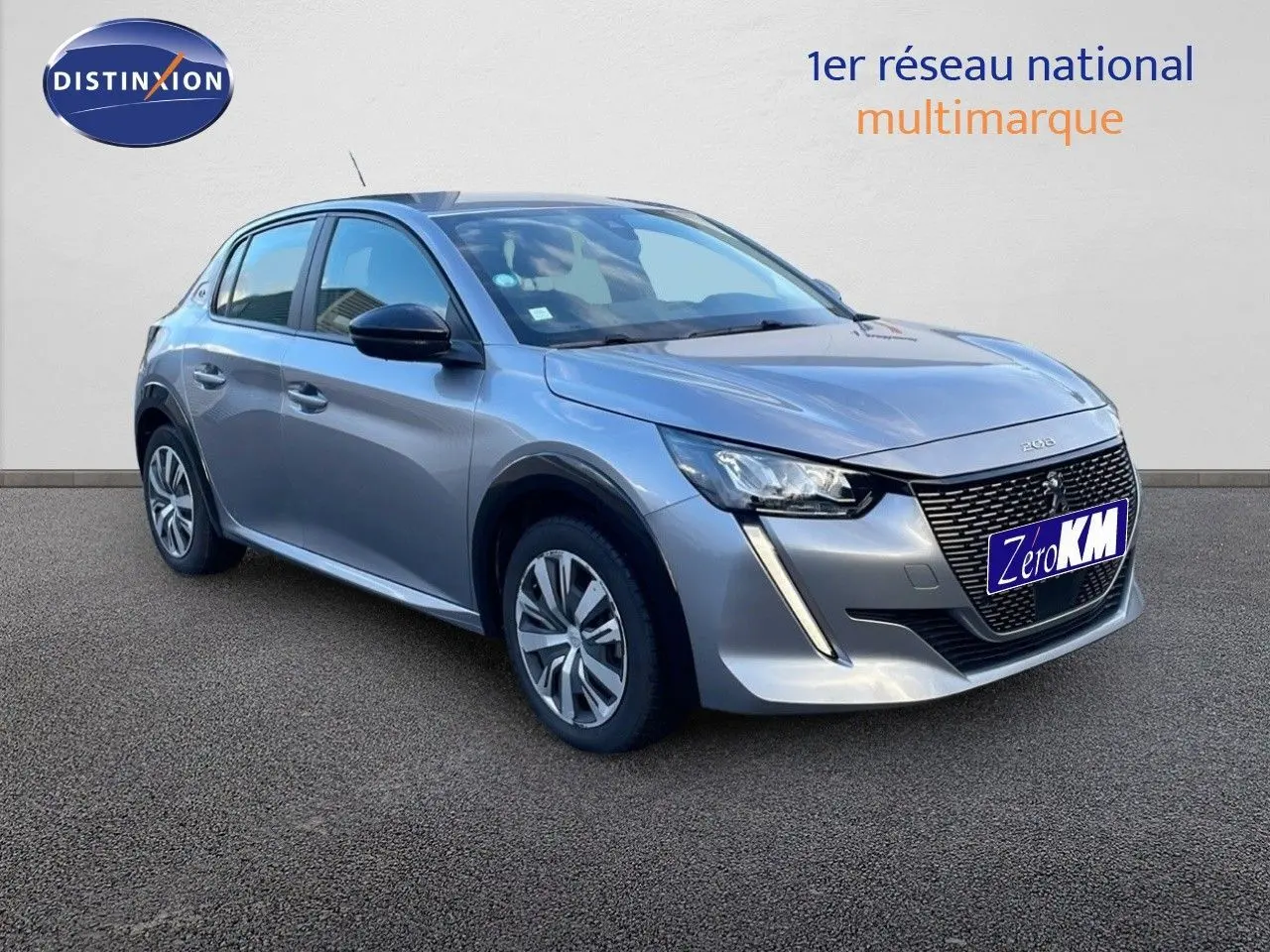 Peugeot 208 électrique gris Artense vue 3/4 avant gauche avec calandre distinctive et feux LED diurnes en forme de griffes.