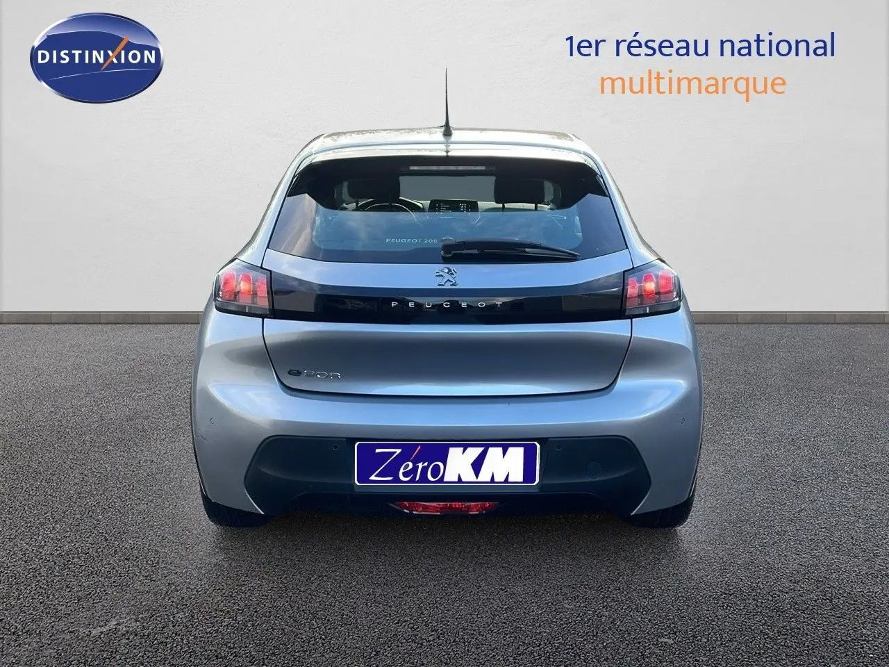 Vue arrière d'une Peugeot 208 électrique gris Artense avec feux arrière distinctifs et logo Peugeot visible.