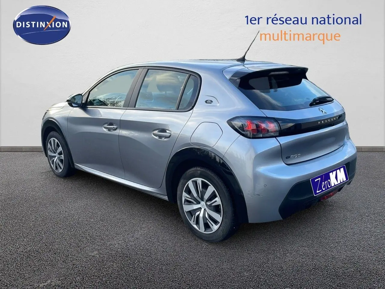 Peugeot 208 électrique gris Artense vue 3/4 arrière côté gauche avec jantes et logo e-208 visibles.