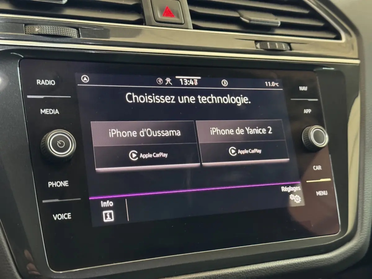 Écran tactile central du Volkswagen Tiguan 2021 affichant la connexion Apple CarPlay, boutons autour visibles.
