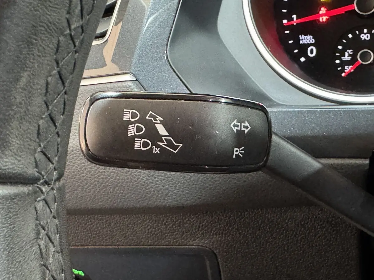 Gros plan sur la manette de clignotants noire du Volkswagen Tiguan 2021, avec tableau de bord partiellement visible.