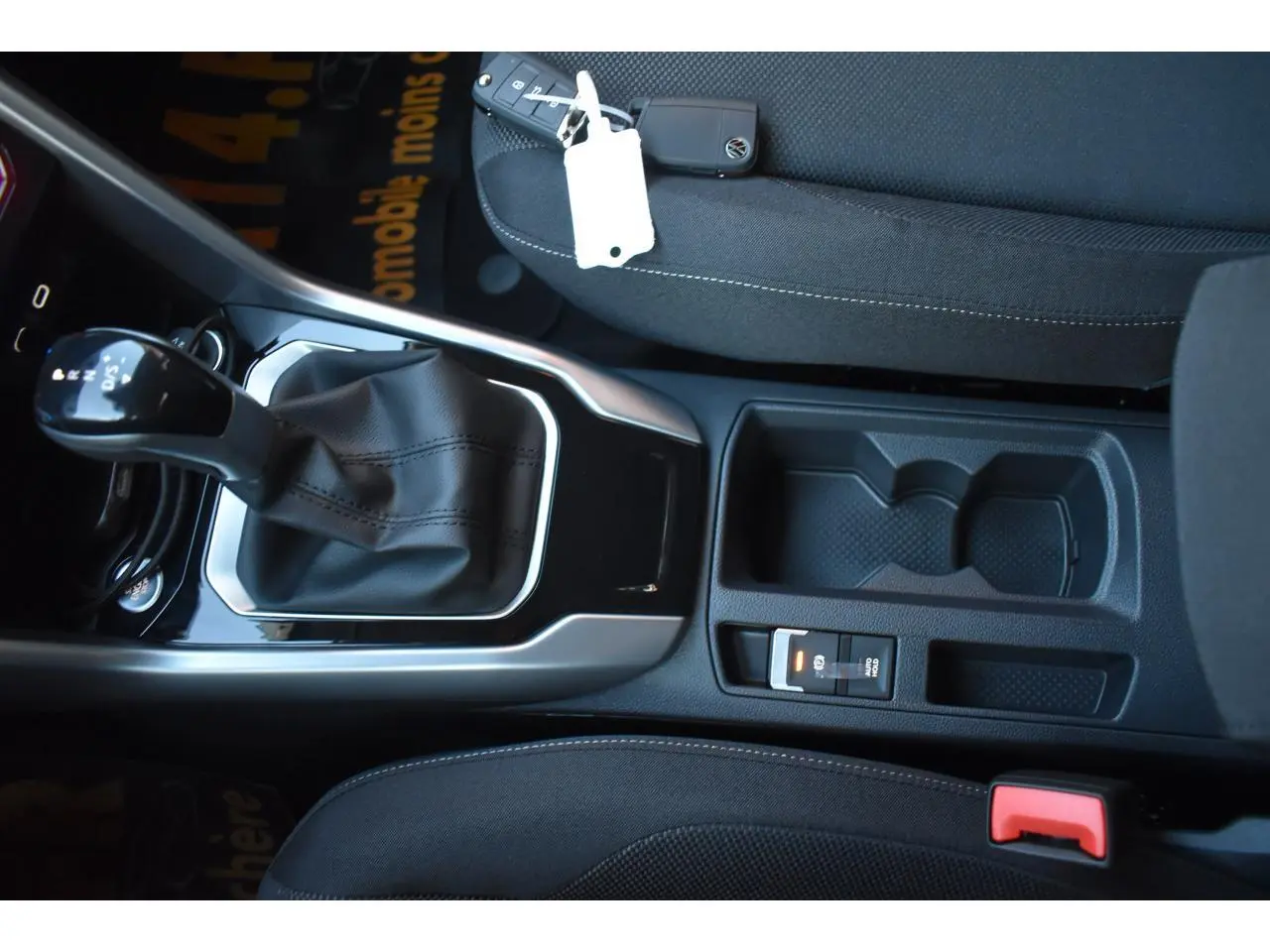 Vue intérieure centrée sur la console centrale du Volkswagen T-Roc 2025, avec levier de vitesse et sellerie noire.