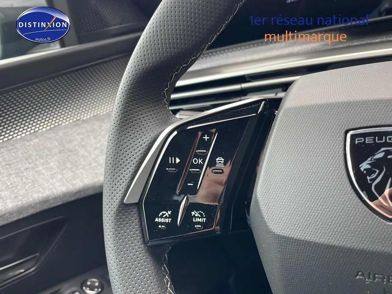 Gros plan sur le volant cuir perforé côté gauche du Peugeot 3008 Hybrid 145 gt e-dcs6 bleu obsession, boutons multifonctions visibles.