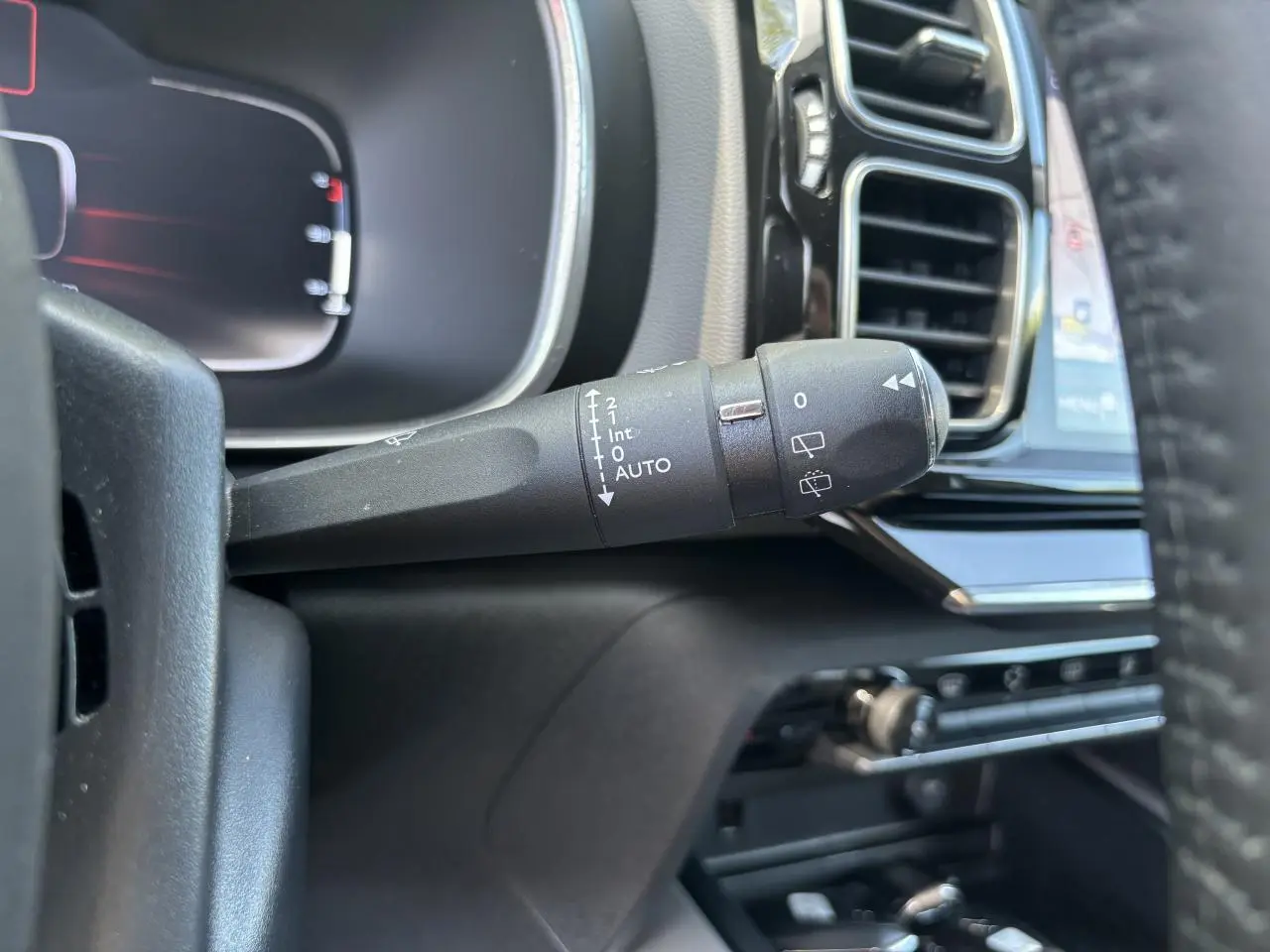 Gros plan sur la commande d'essuie-glace à gauche du volant dans l'habitacle noir du Citroën C5 Aircross Shine 2019.