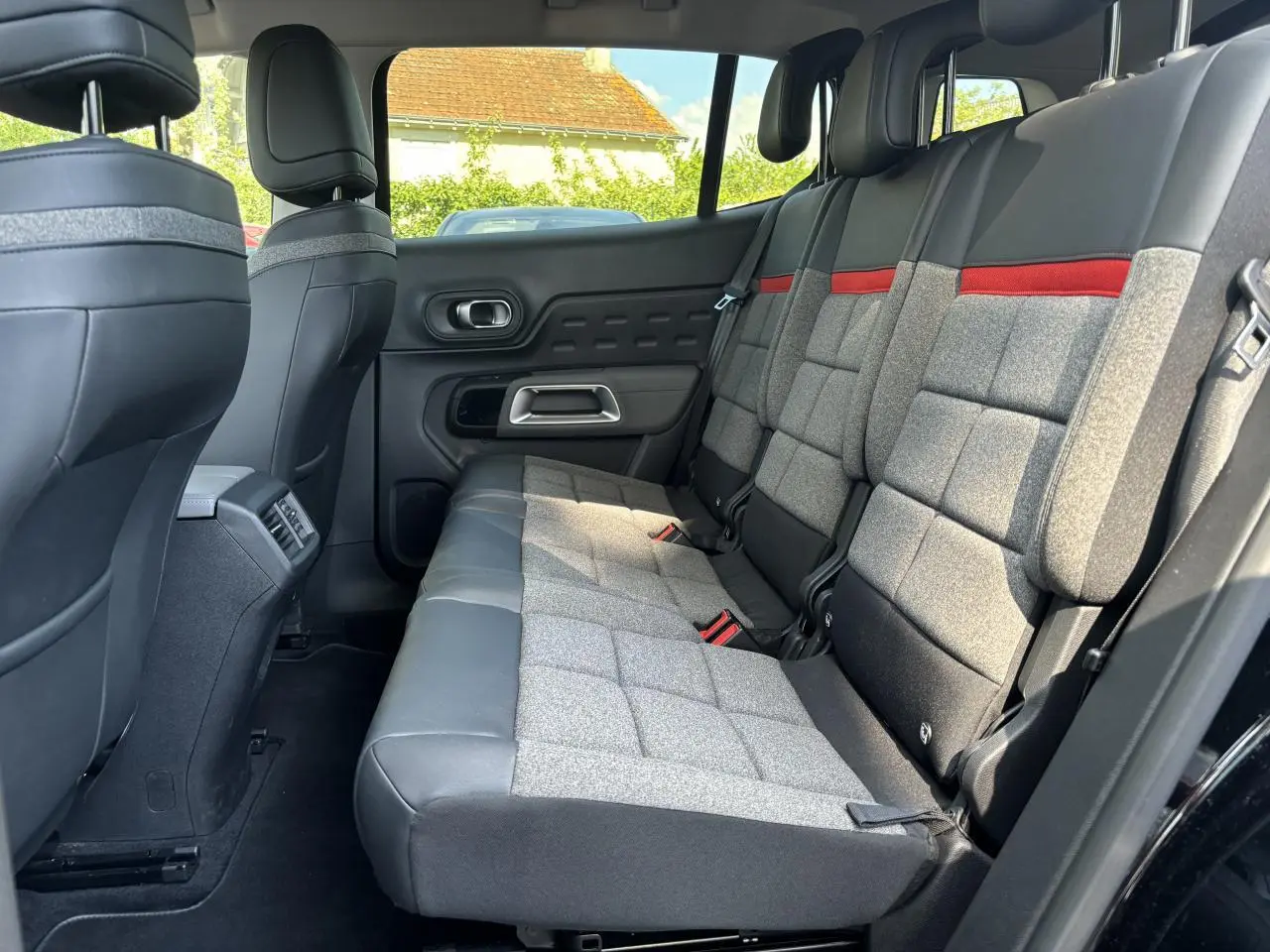 Vue intérieure arrière côté droit du Citroën C5 Aircross 2019 noir, montrant les sièges arrière gris avec bande rouge.