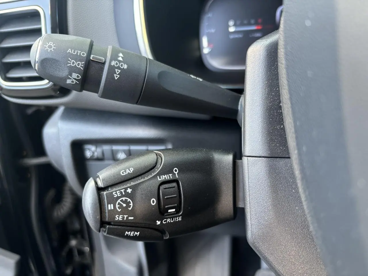 Gros plan sur les commandes de régulateur de vitesse et éclairage du Citroën C5 Aircross 2019 noir métallisé.