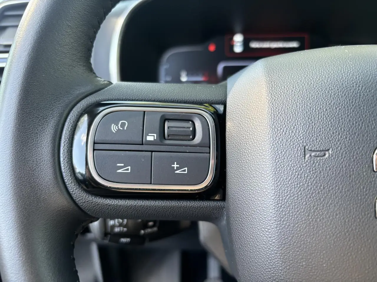 Gros plan sur les commandes au volant à gauche du Citroën C5 Aircross noir métallisé de 2019.