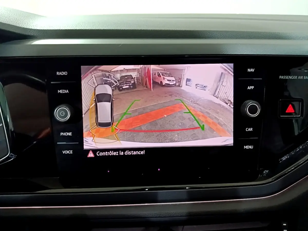 Affichage de la caméra de recul du Volkswagen Taigo blanc, vue arrière avec guidage de stationnement sur écran central.