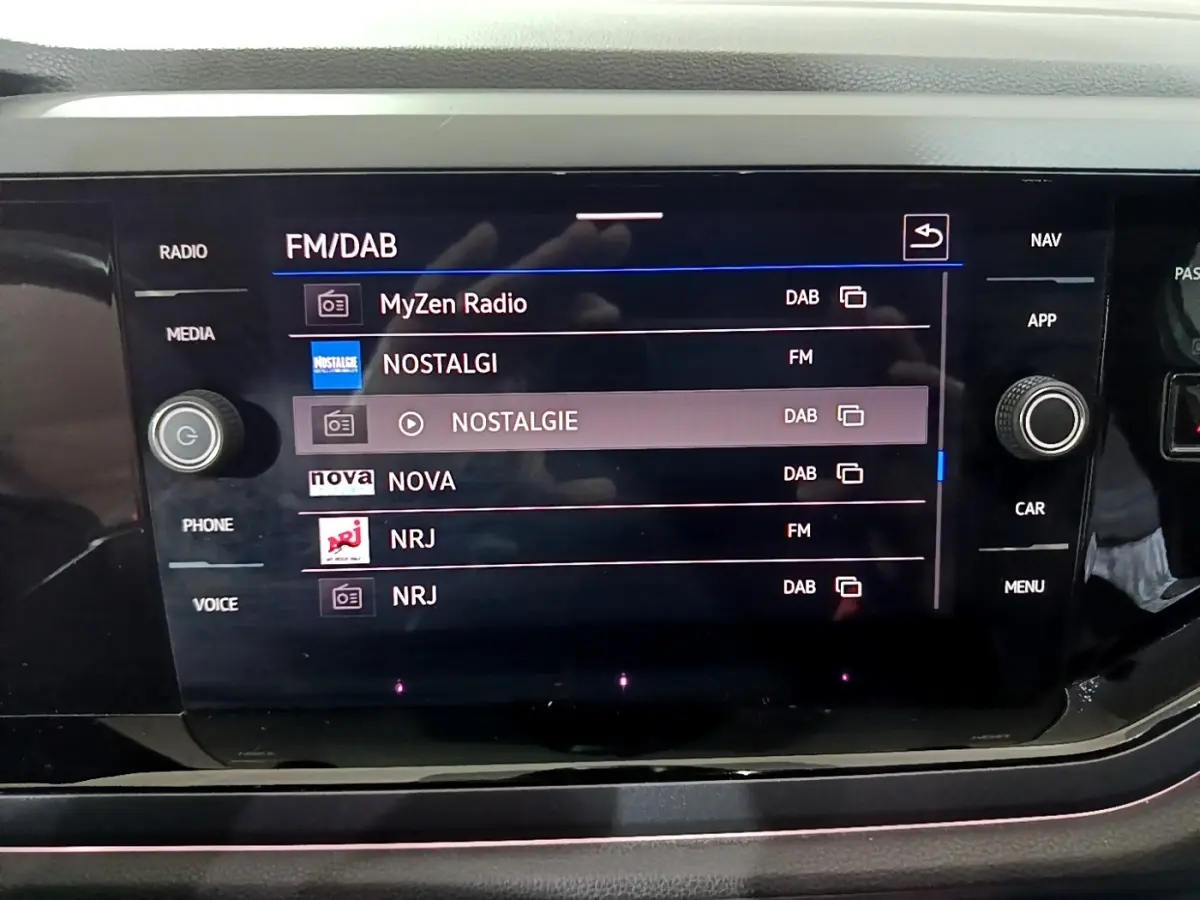 Écran tactile central du Volkswagen Taigo 2022 affichant les stations radio FM/DAB avec commandes autour.
