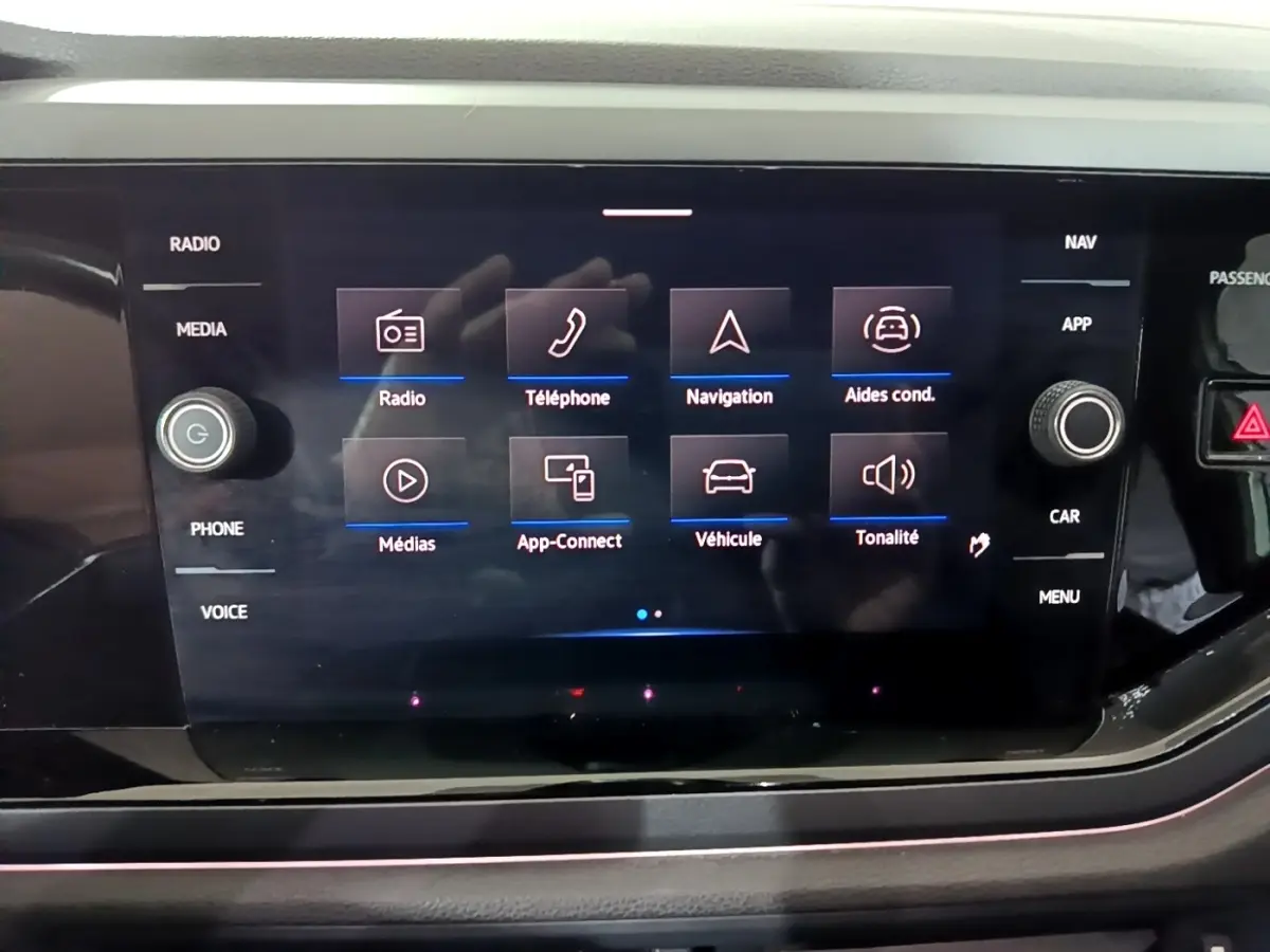 Vue rapprochée de l'écran tactile central du Volkswagen Taigo blanc, affichant le menu multimédia et navigation.