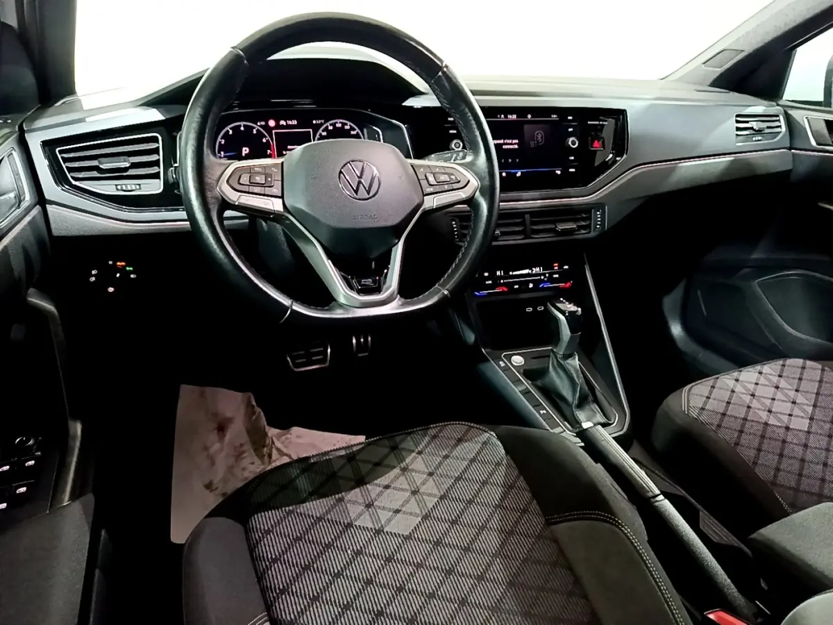 Vue intérieure avant du Volkswagen Taigo 1.0 TSI 110 DSG R-Line, volant cuir alu multifonctions et tableau de bord digital.