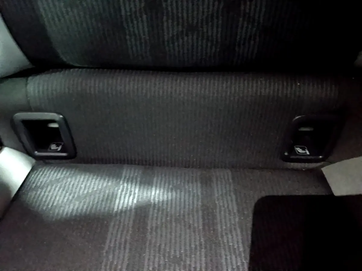 Détail de la banquette arrière noire du Volkswagen Taigo 1.0 TSI 110 DSG R-Line, avec commandes de rabattement intégrées.