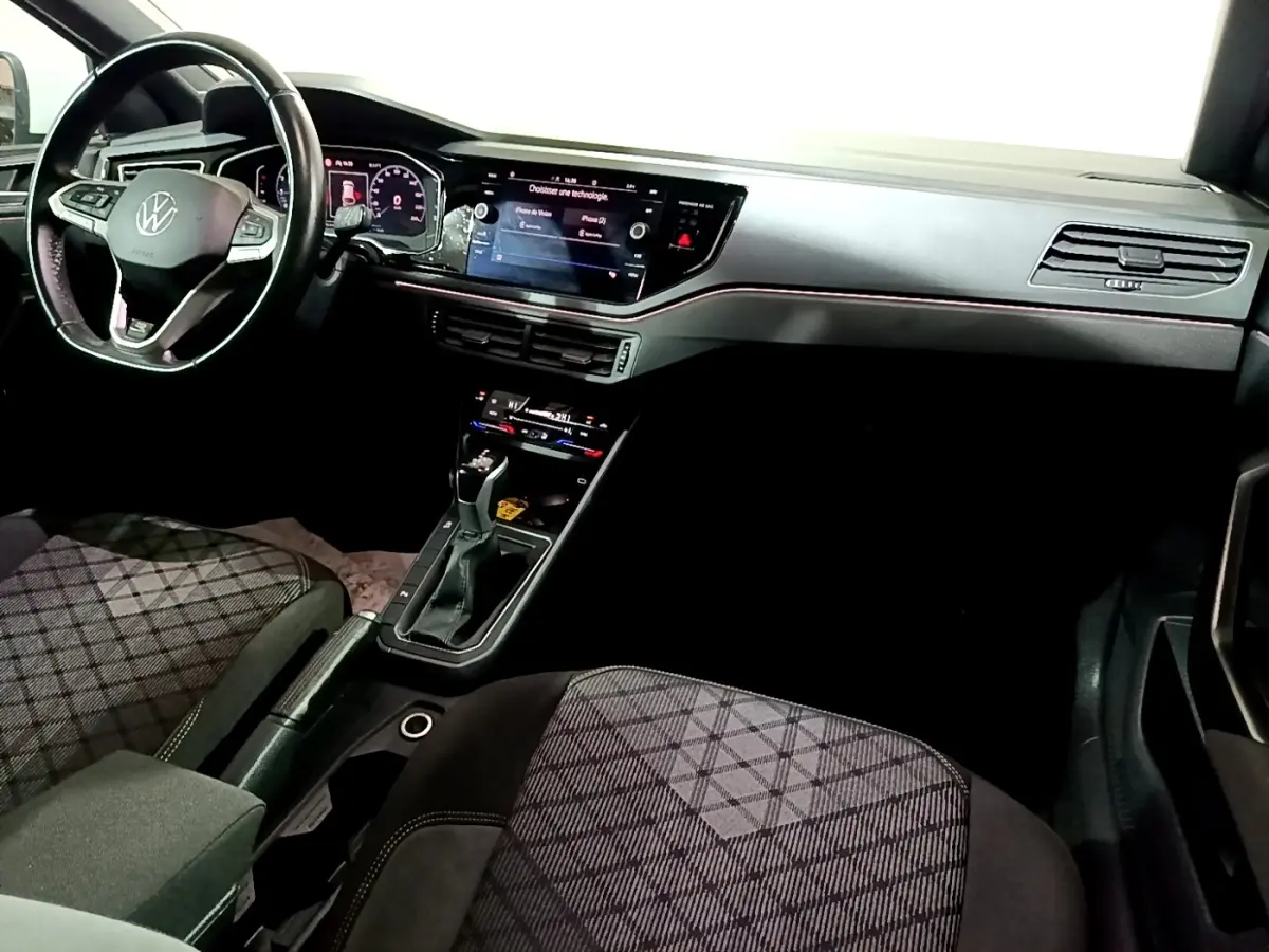 Vue intérieure côté conducteur du Volkswagen Taigo 1.0 TSI 110 DSG R-Line avec volant cuir alu et tableau de bord digital.