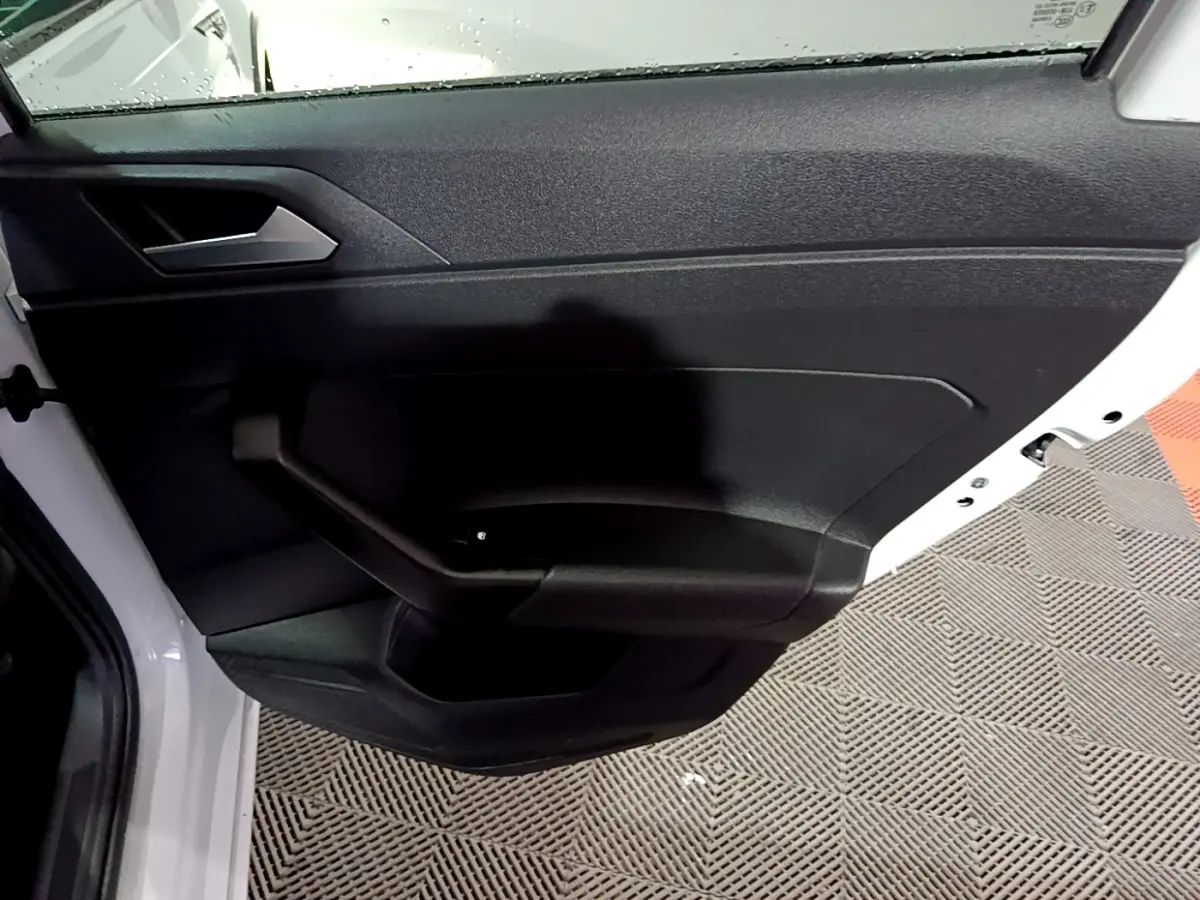 Vue rapprochée de la porte arrière gauche noire du Volkswagen Taigo blanc 2022, avec poignée intégrée.