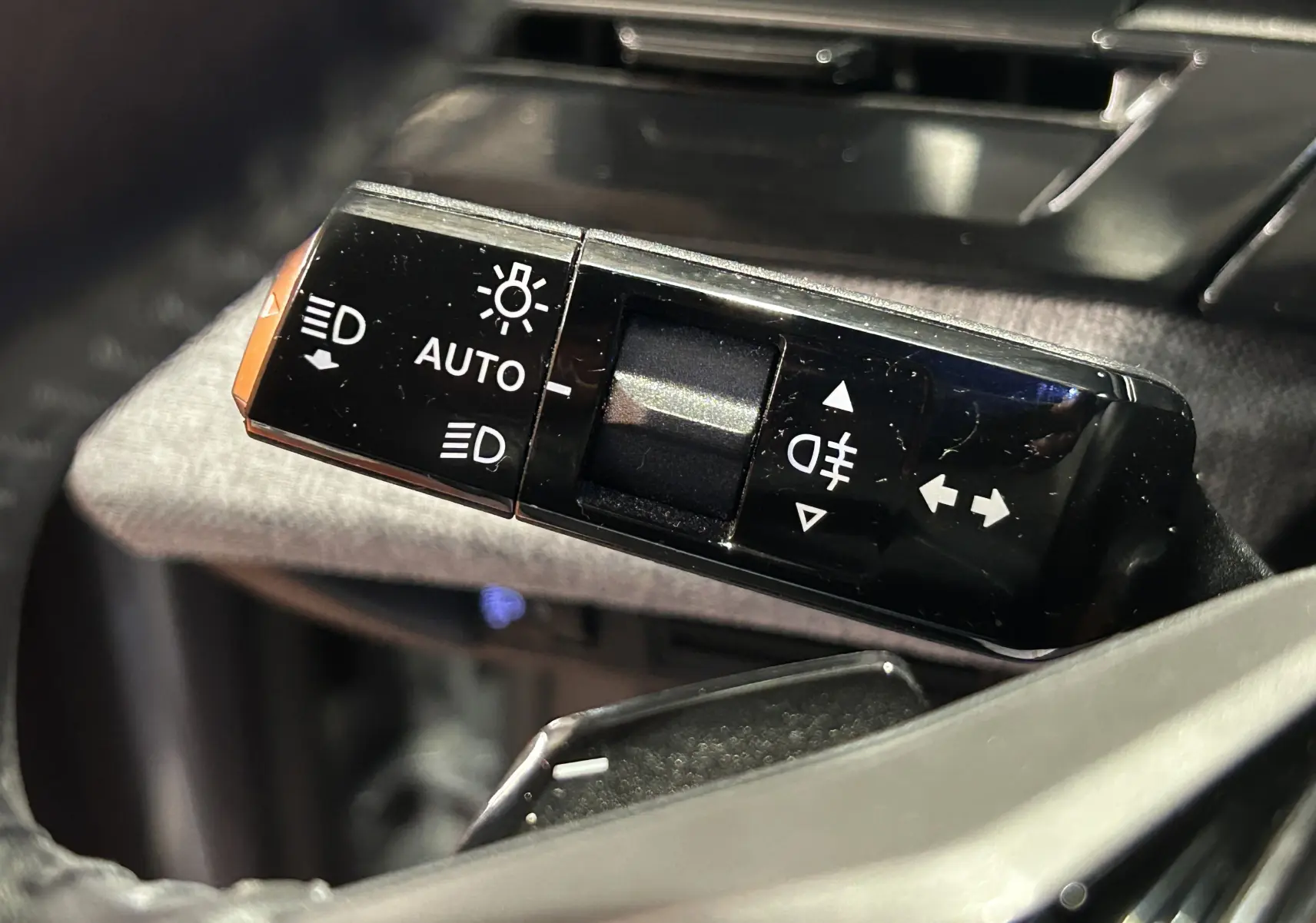 Gros plan sur la commande des feux et clignotants du Peugeot 5008 III Hybrid 145 e-DCS6 Allure en intérieur.