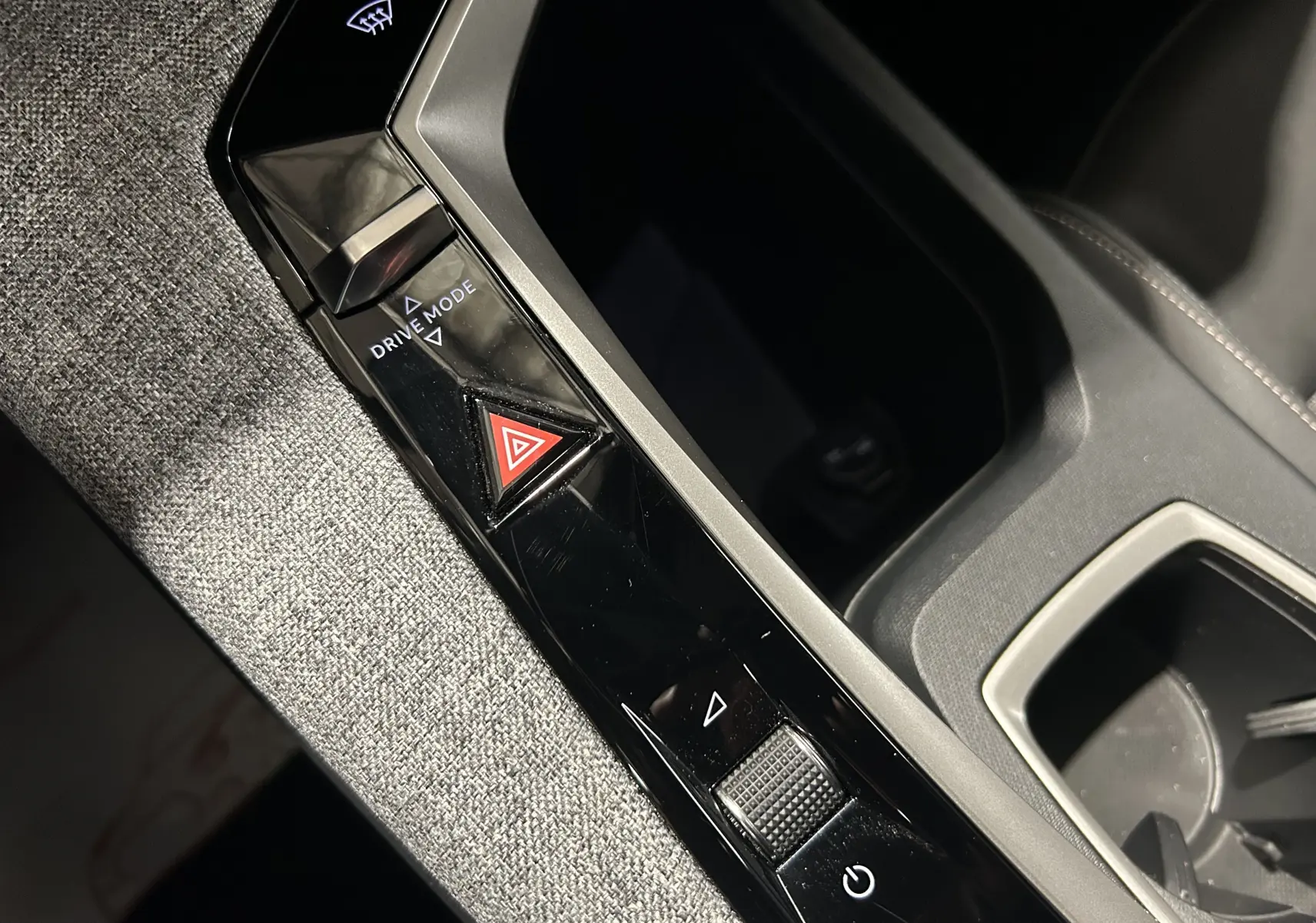 Gros plan sur la console centrale du Peugeot 5008 gris Artense, mettant en valeur les commandes Drive Mode et le bouton de warning triangulaire rouge.