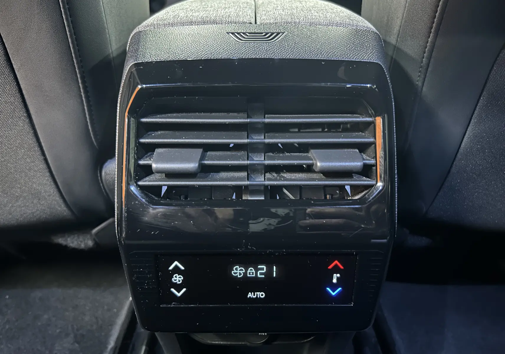 Vue rapprochée de la console de climatisation arrière du Peugeot 5008 gris Artense, avec affichage digital à 21°C.