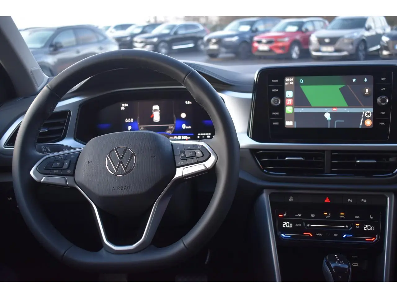 Vue intérieure centrée sur le volant multifonction et l'écran tactile du Volkswagen T-Roc 2025, ambiance moderne et épurée.