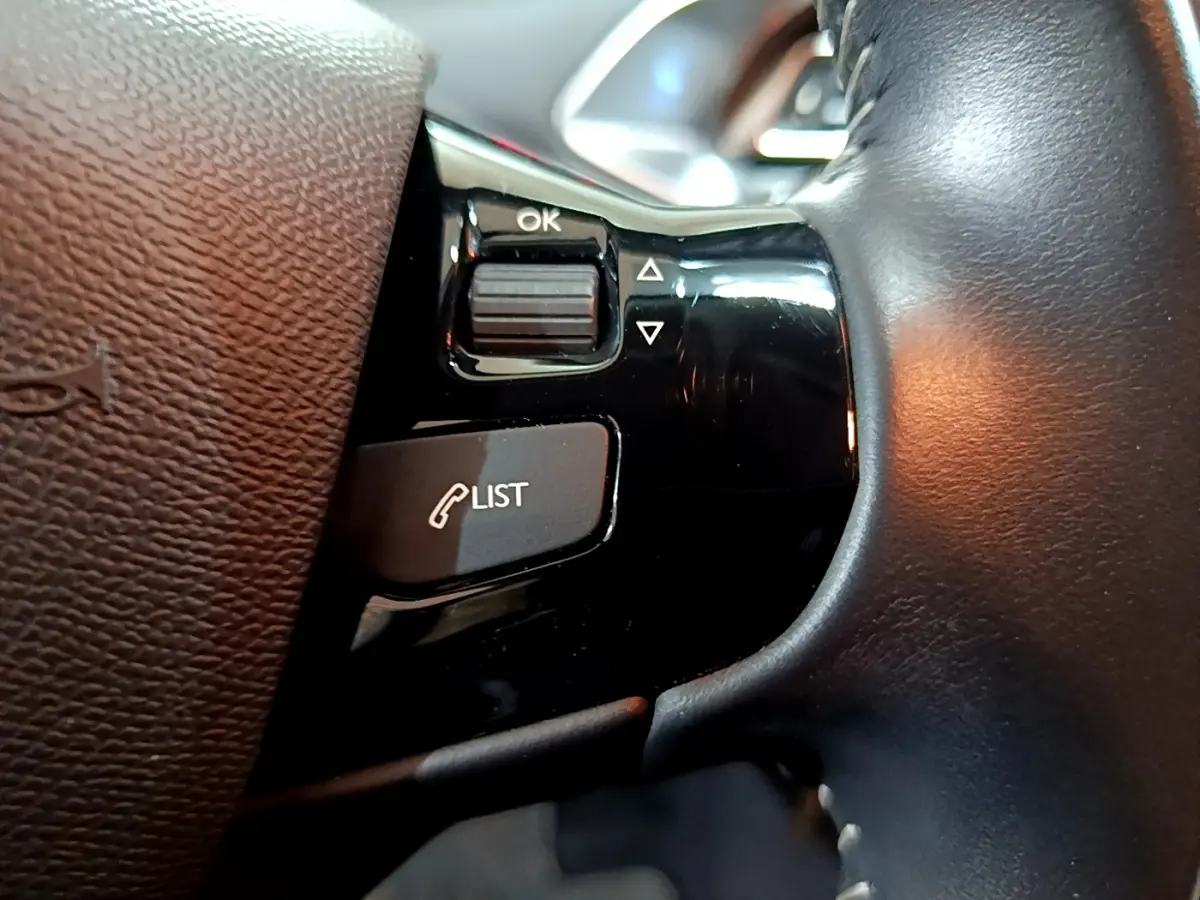 Gros plan sur les commandes noires du volant cuir de la Peugeot 308 gris clair Puretech 110 S&S Style 2020