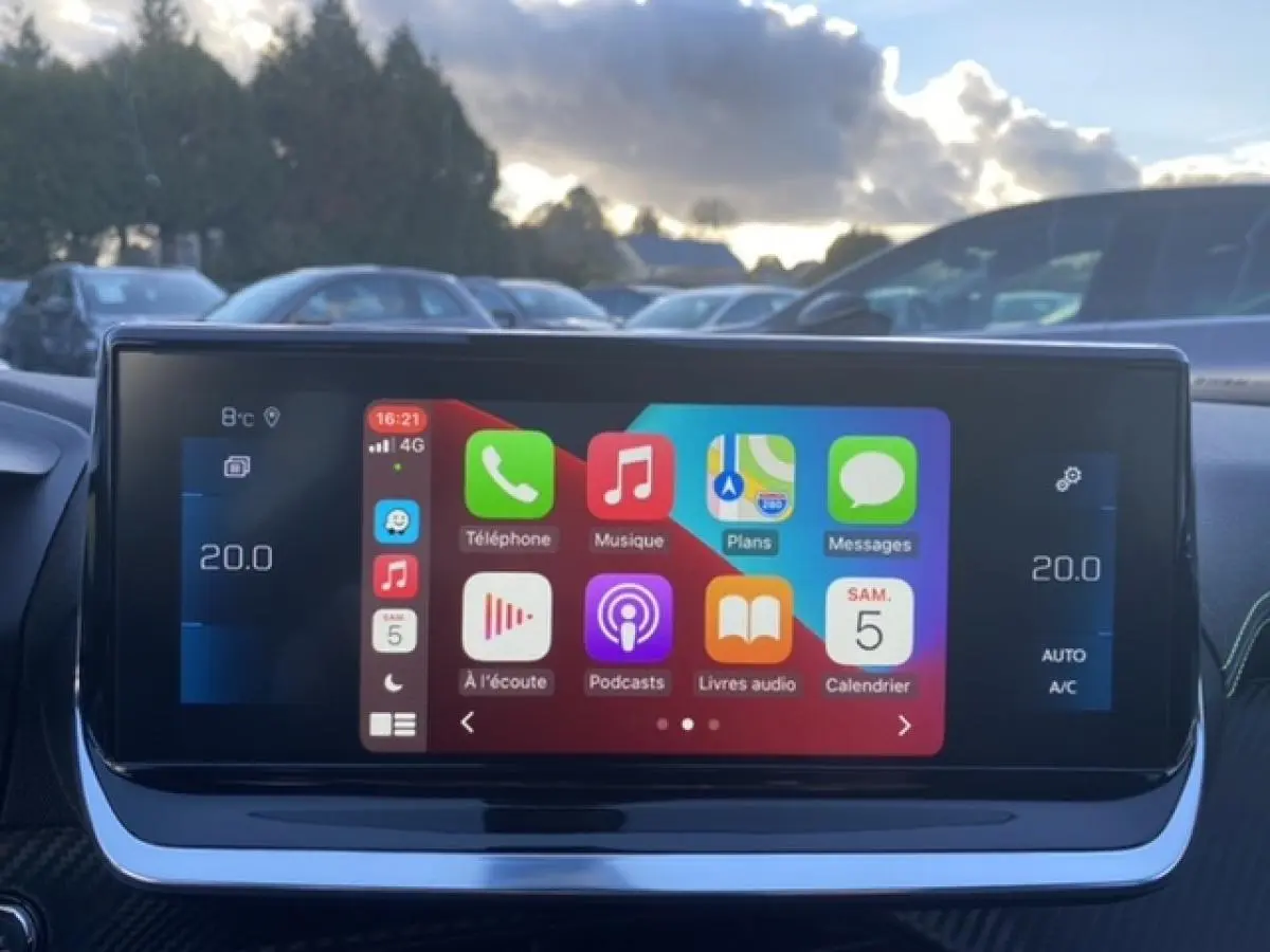 Écran tactile 10 pouces du Peugeot 2008 noir 2021 affichant interface Apple CarPlay en extérieur.