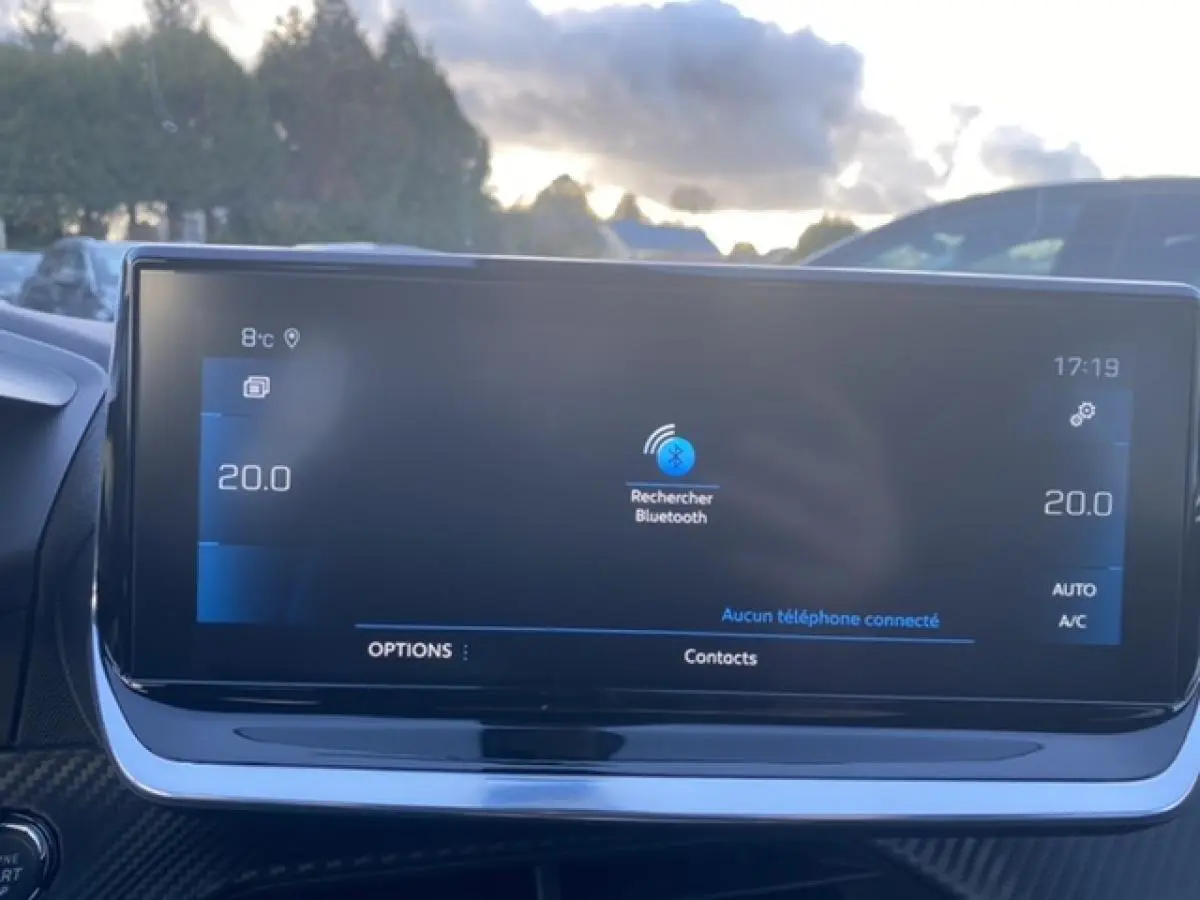 Écran tactile central du Peugeot 2008 noir 2021 affichant la recherche Bluetooth, avec tableau de bord en arrière-plan.