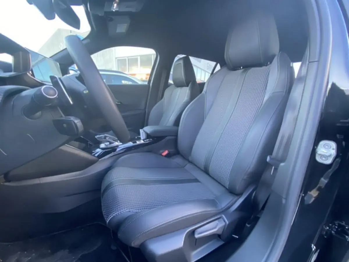 Intérieur avant droit du Peugeot 2008 noir 2021, siège en cuir et tissu avec console centrale visible.