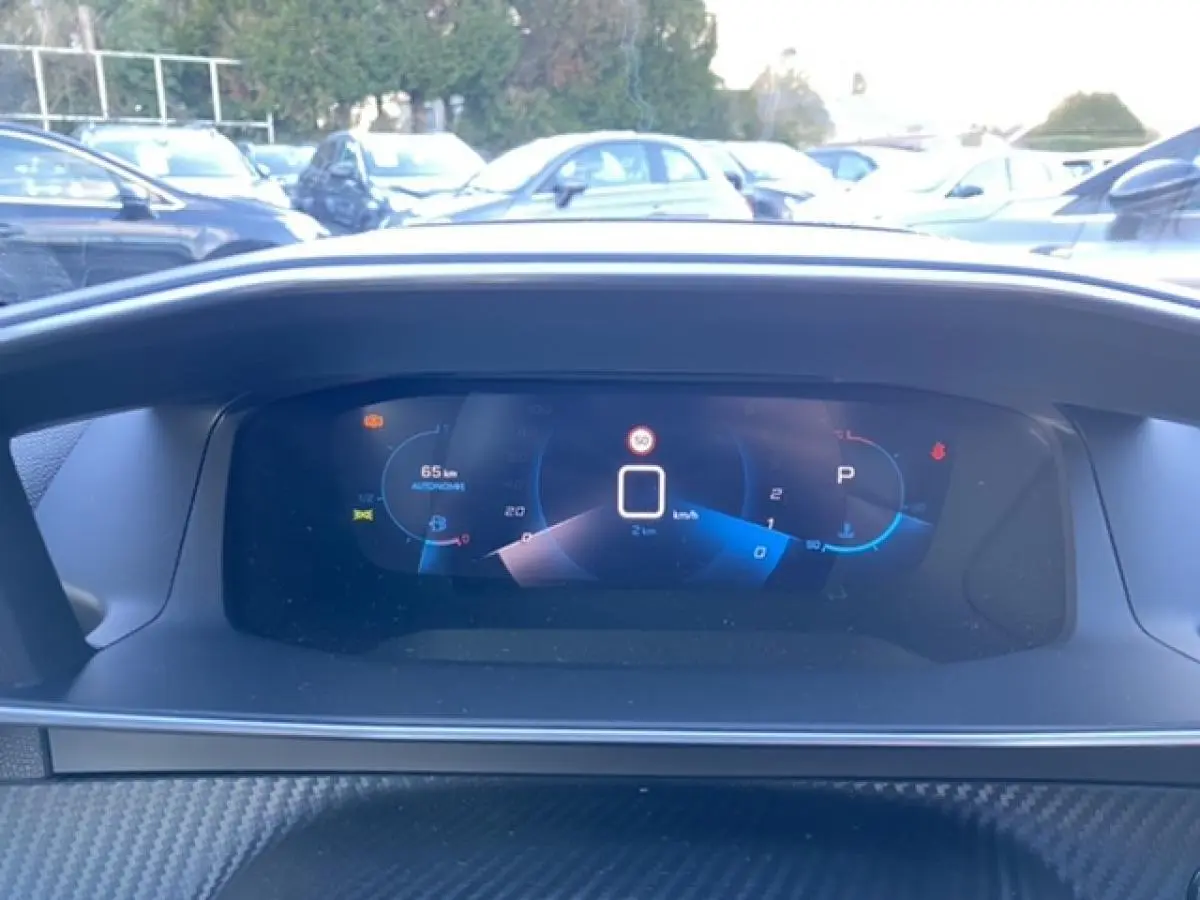 Vue rapprochée du combiné numérique 3D du tableau de bord du Peugeot 2008 noir, affichant la vitesse et l'autonomie.