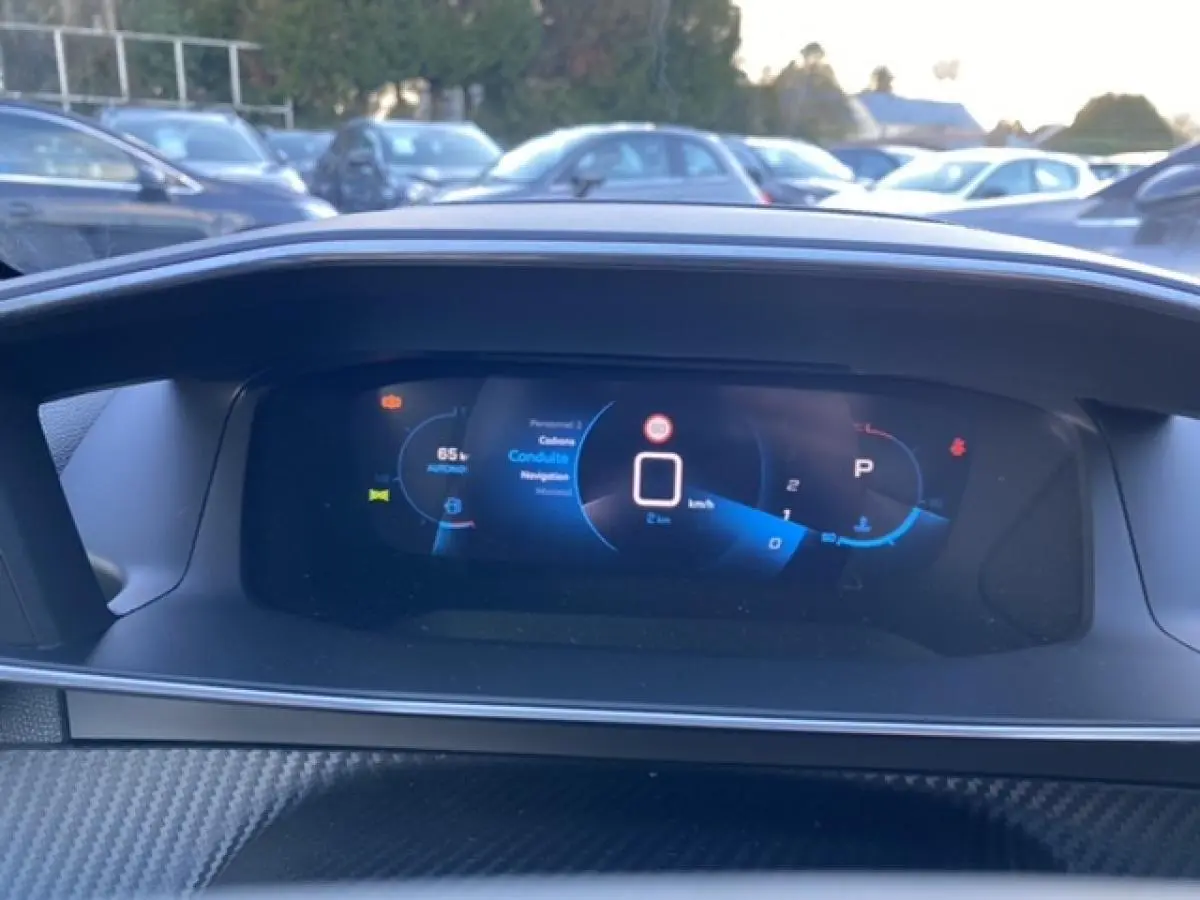 Vue rapprochée du combiné numérique 3D du Peugeot 2008 noir 2021, affichant la vitesse et les aides à la conduite.