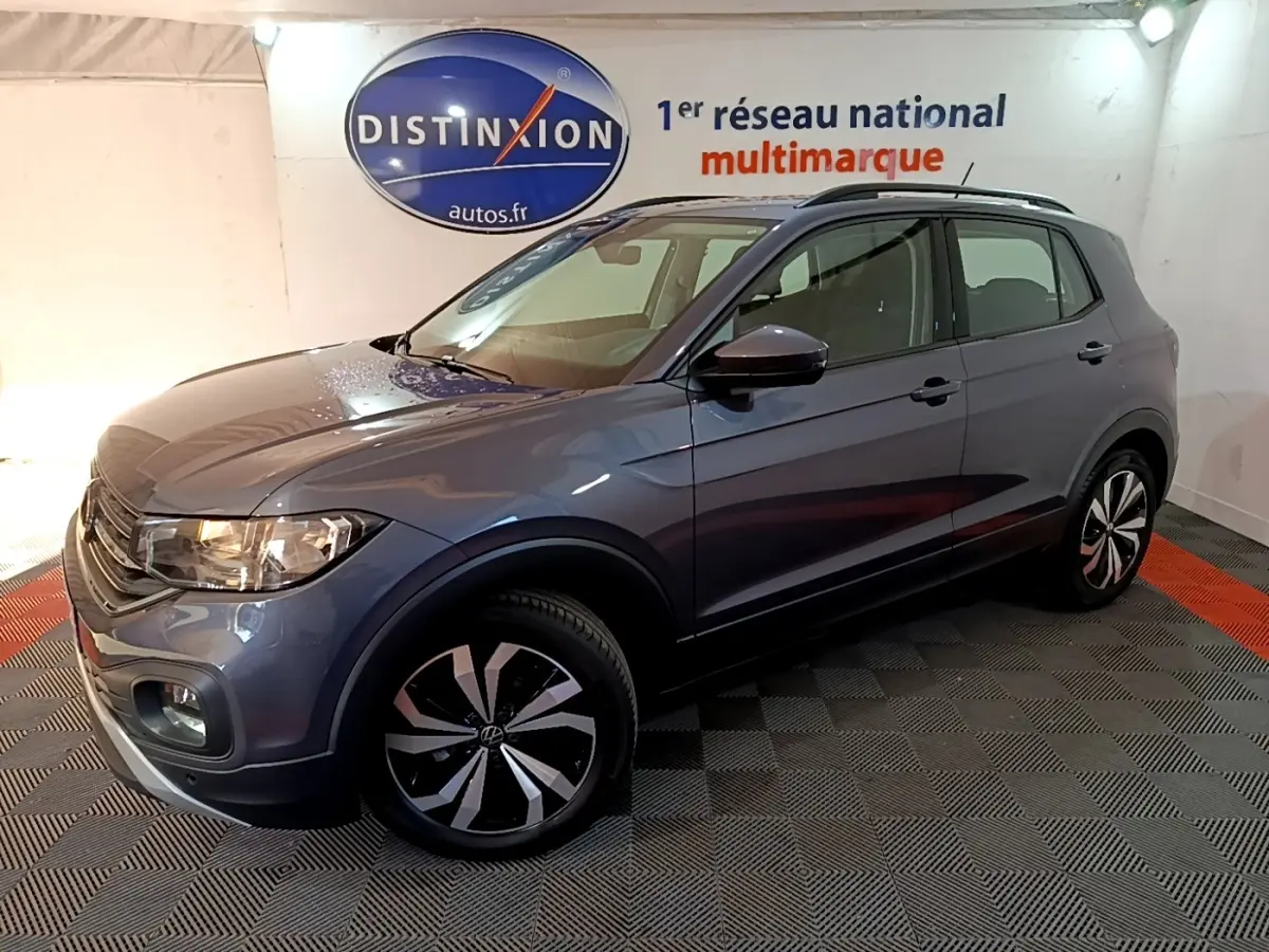 Volkswagen T-Cross gris foncé en 3/4 avant droit, avec jantes distinctives et toit noir en showroom.