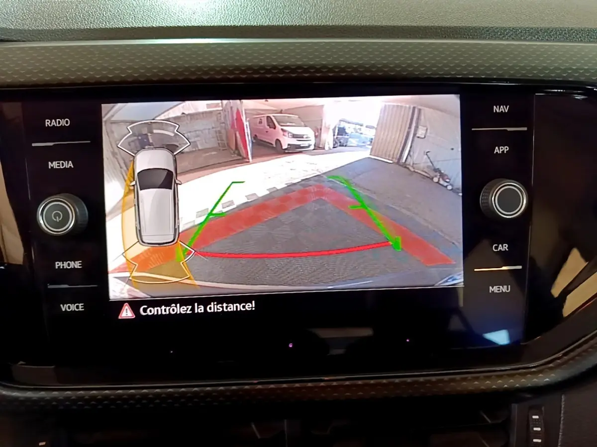 Écran tactile du Volkswagen T-Cross gris foncé montrant la caméra de recul avec guidage de trajectoire en parking.
