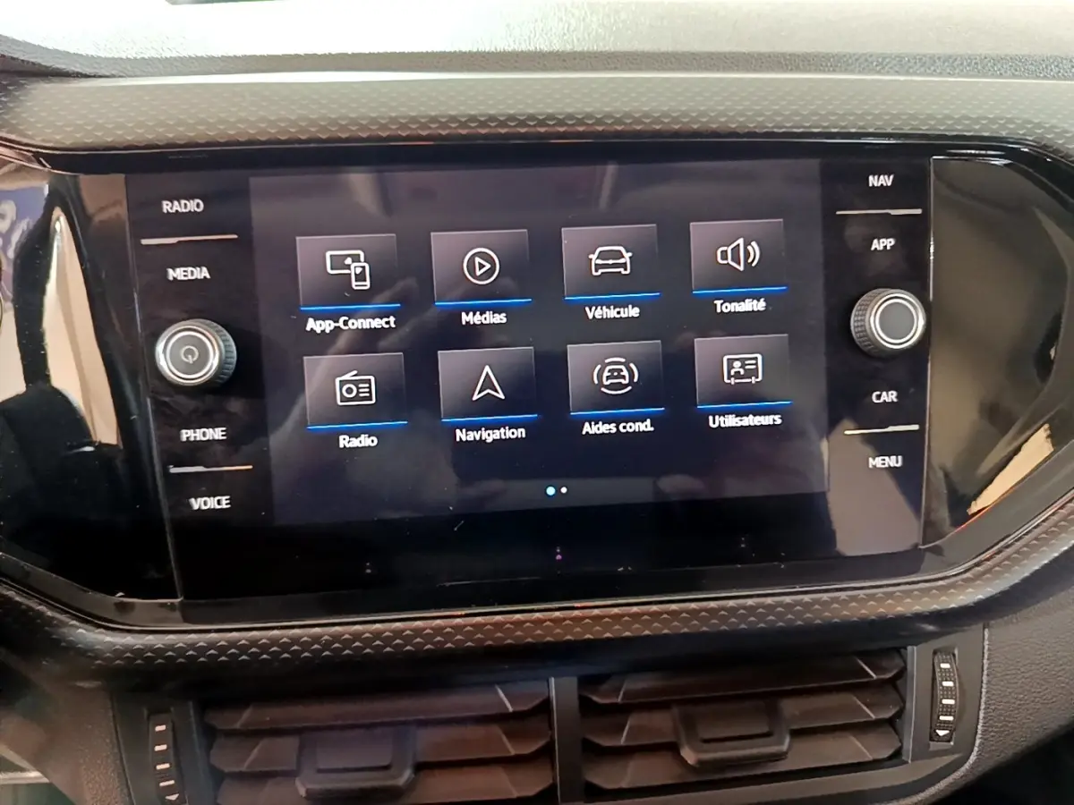 Écran tactile central du Volkswagen T-Cross gris foncé, affichant le menu multimédia et navigation.