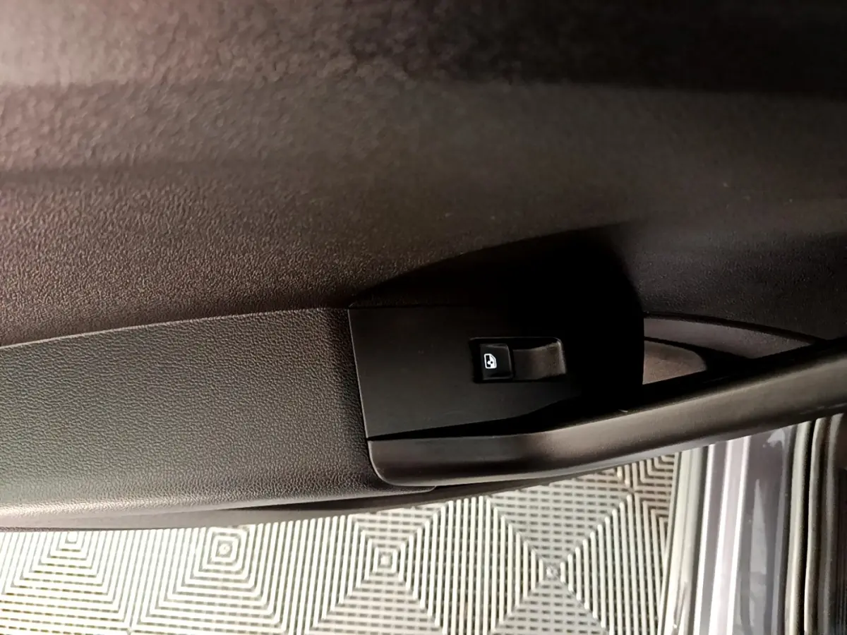 Détail de la poignée intérieure de porte arrière droite du Volkswagen T-Cross gris foncé 2023.