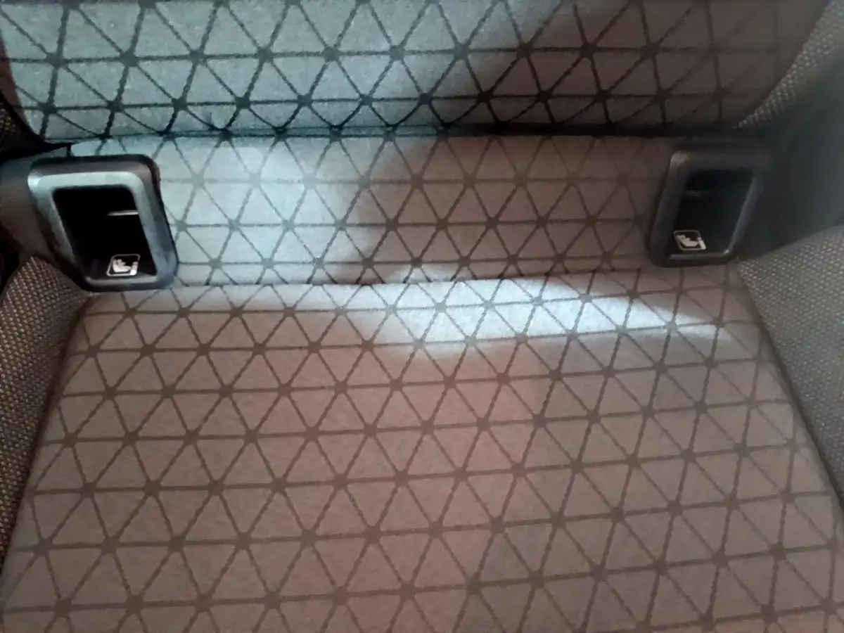 Gros plan sur la banquette arrière gris foncé du Volkswagen T-Cross avec fixation Isofix visible de face.