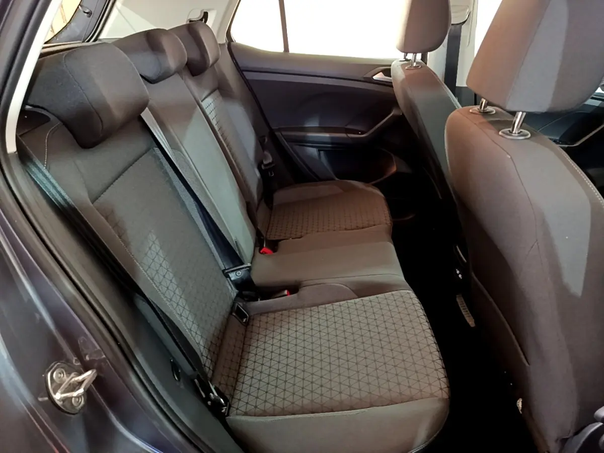 Vue intérieure côté gauche sur la banquette arrière grise foncée du Volkswagen T-Cross 2023 avec appuie-têtes et ceintures visibles.