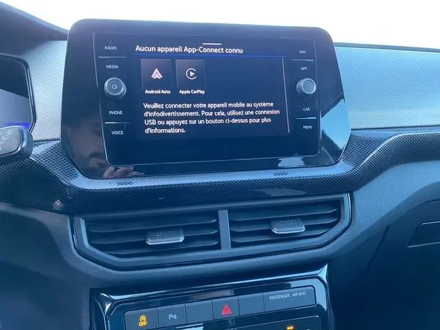 Vue rapprochée de l’écran tactile central du tableau de bord du Volkswagen T-Cross noir, affichant le menu App-Connect.