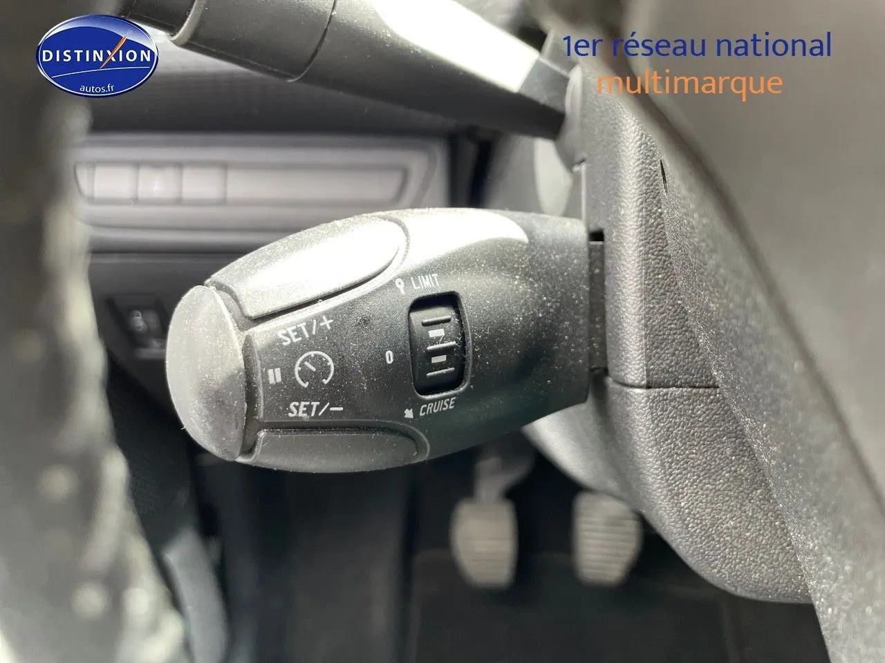 Gros plan sur la commande de régulateur de vitesse du Peugeot 2008 noir métal, côté gauche du volant.