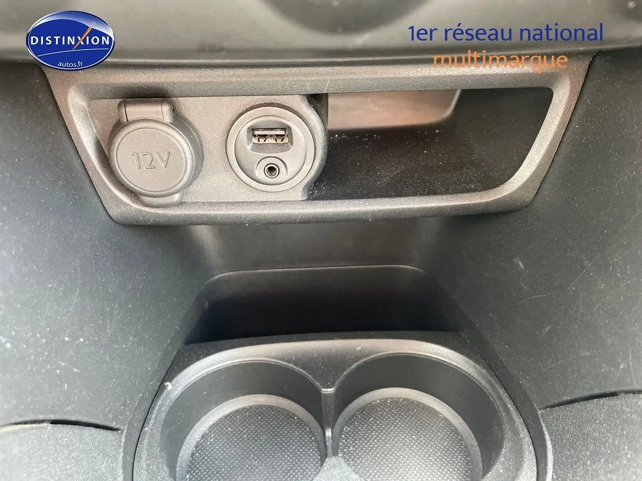 Prise 12V et port USB intégrés dans la console centrale d'une Peugeot 2008 noire, version 2016 essence.